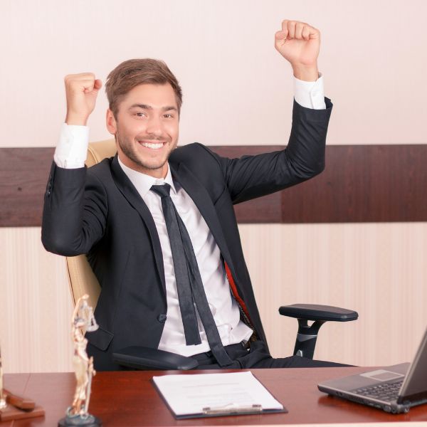 Handsome lawyer sitting at the table and holding hands up feeling overjoyed