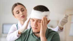 a nurse tending to the patient’s head injury