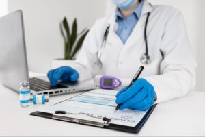 Close-up doctor working on laptop