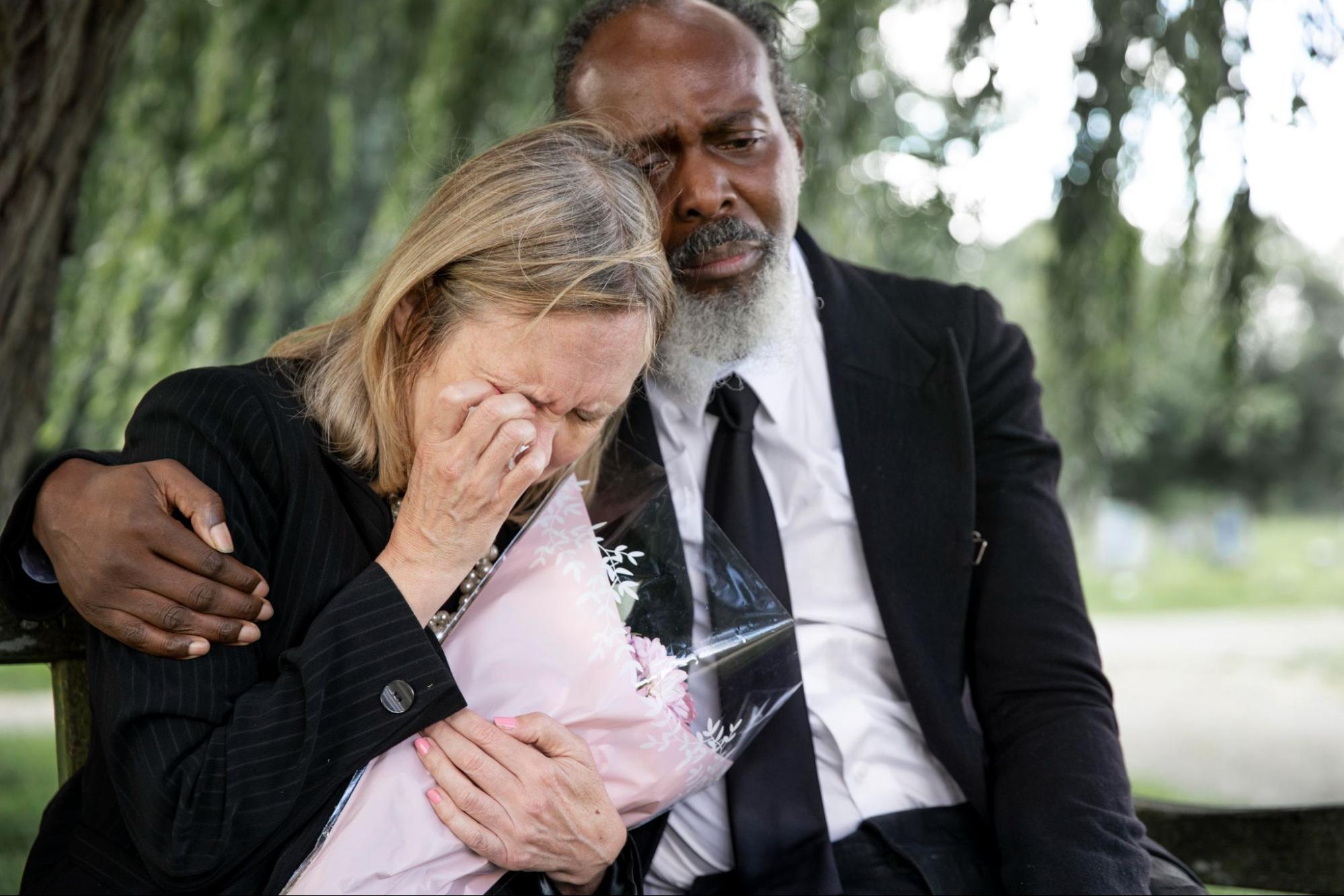 Two people visiting a grave