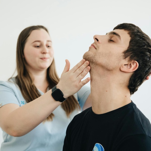 a nurse checking a patient’s neck movement.