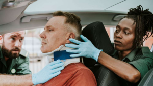 A woman inspecting a man’s injured neck